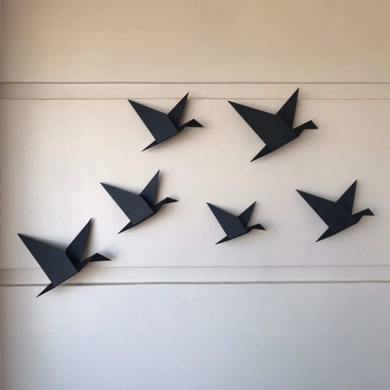 Two sets of black Gheyya wall art hung on a balcony wall