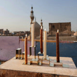 Two stainless steel candleholders holding a total of five candles, featured in a photoshoot on a rooftop in Egypt
