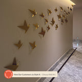 A collection of gold Gheyya wall art pieces hung on a wall.