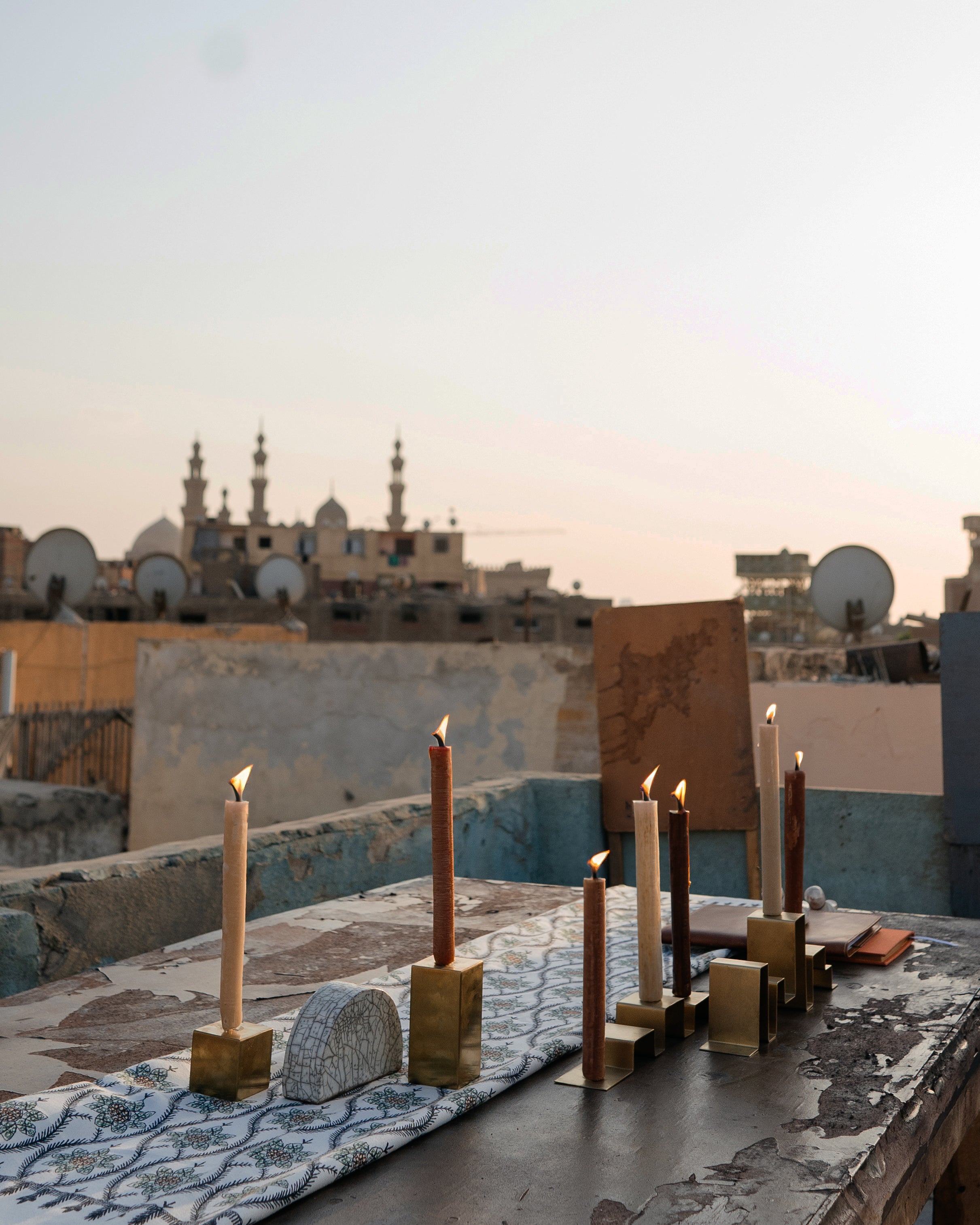 Two stainless steel candleholders holding a total of five candles, featured in a photoshoot on a rooftop in Egypt