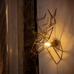 A geometric deer head is attached to an eight-sided marble shape and hung on the wall