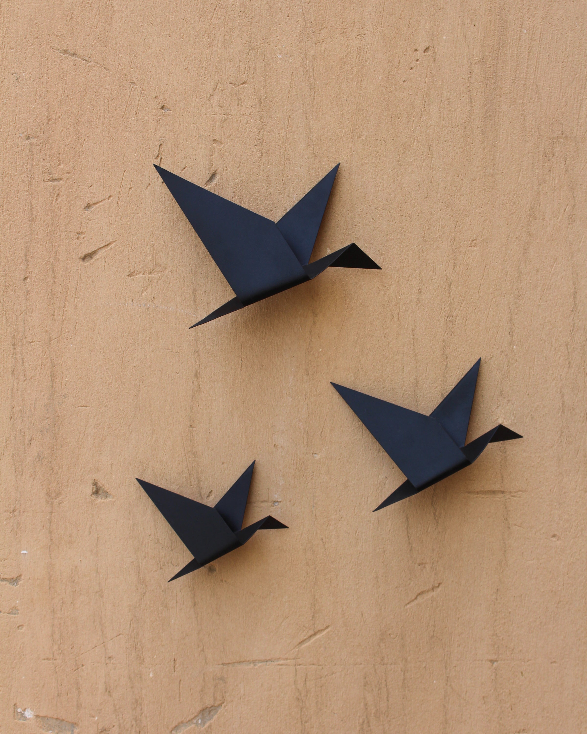 A set of black Gheyya wall art hung on a wall 