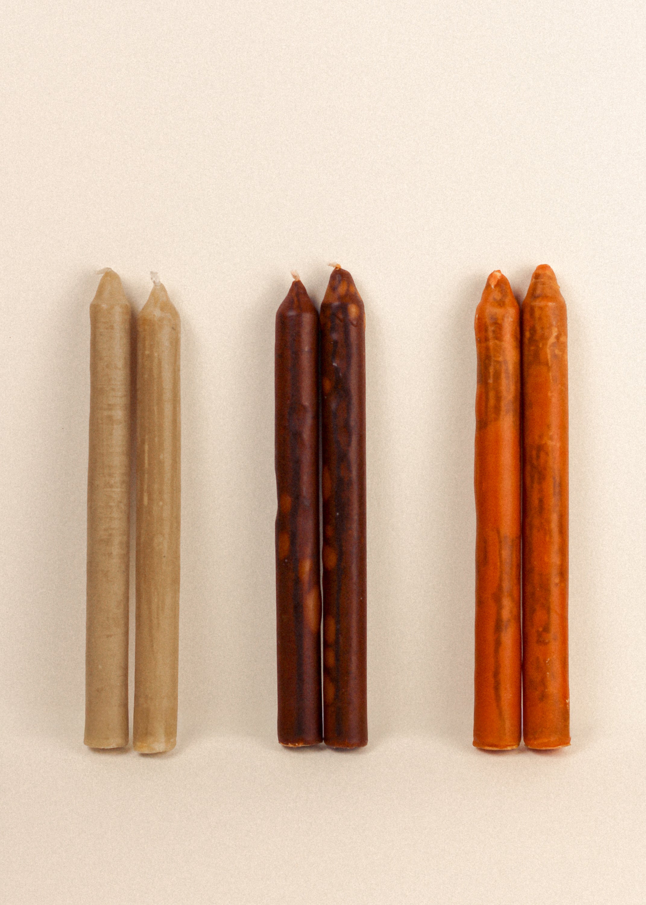 Set of six textured taper candles in brick, dust, and cotton colors